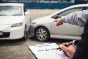 Insurance adjuster taking notes after a car accident