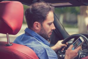 man driving distracted and texting