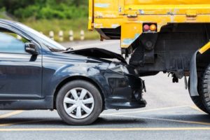 Car that has ridden under a large truck causing a collision
