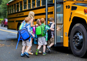 children walking into a school bus