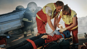 paramedics helping someone severely injured in a traffic accident