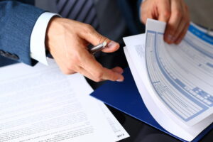 close up of man rifling through paperwork and forms