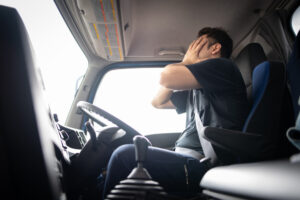 Male truck driver holding his face